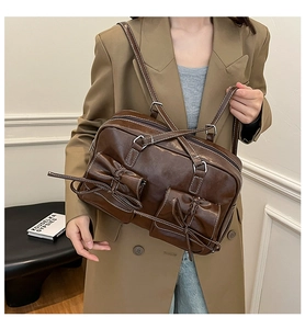 Detail of dark brown shoulder bag with bow accents and contrast white stitching
