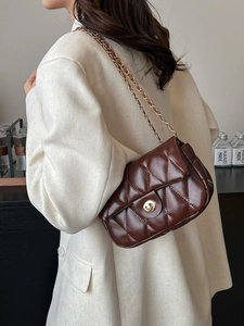 Quilted dark brown chain shoulder bag with gold turn-lock on cream blazer outfit