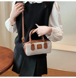 Detailed close-up of canvas and brown leather patchwork on retro Boston handbag