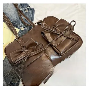 Detail of dark brown vintage PU leather bag with bow pockets and contrast stitching
