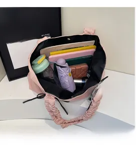 Intérieur du cabas en nylon rose montrant sa grande capacité pour parapluie et tablette
