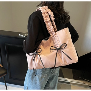 Détail du sac cabas rose en toile avec double nœud et bandoulière à effet froissé