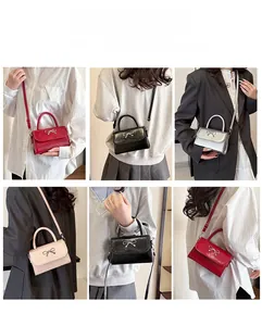 Detail showing mini crossbody square bags in red, black, silver, and pink with metal bow