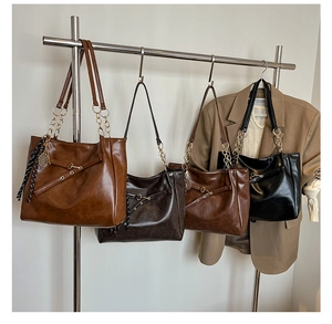 Macro detail of vintage wax leather tote bags in four colors with gold chain straps