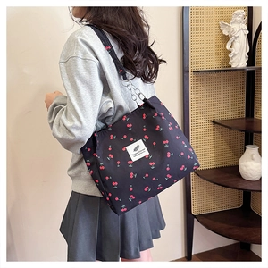 Detail of black cherry print canvas tote bag with chain strap and vintage interior decor