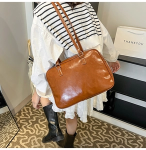 Detail of vintage brown oil wax leather shoulder bag with glossy finish and silver buckles