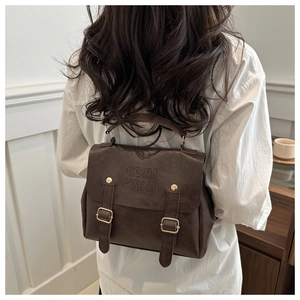Detail des dunkelbraunen Vintage-Rucksacks mit Lederstruktur und goldenen Schnallen
