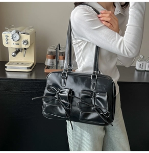 Shoulder bag detail showing bow knots, double pockets, and contrast white stitching