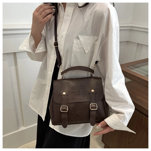 Detailansicht der dunkelbraunen Leder-Schultertasche mit geprägtem Logo und Metallschnallen