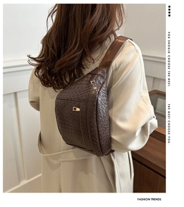 Détail de la texture tressée en cuir PU marron foncé et fermoir doré du sac bandoulière