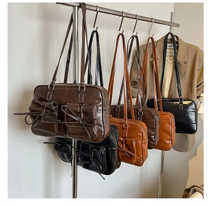 Detailed view of vintage PU leather shoulder bags with bow pockets and sleek long straps