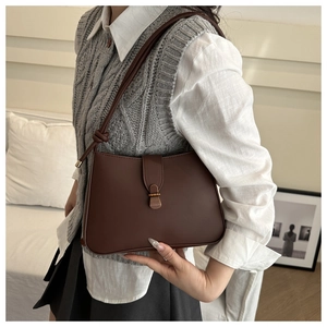 Dettaglio borsa vintage in pelle marrone con elegante fibbia in metallo dorato