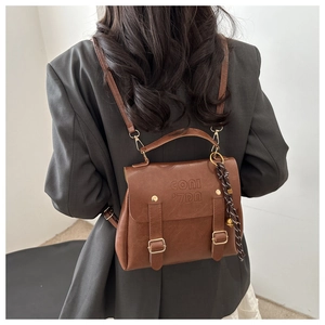Detailansicht brauner Lederrucksack mit goldener Schnalle und Logoprägung