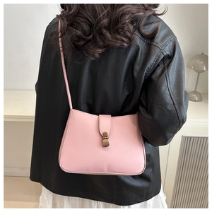 Borsa a tracolla in pelle rosa con fibbia in rame vintage indossata con una giacca di pelle