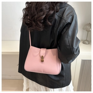 Dettaglio di una borsa sottobraccio rosa in ecopelle con chiusura in metallo vintage liscia