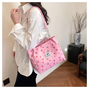 Detailed close-up of pink cherry print nylon shoulder bag with silver chain and logo