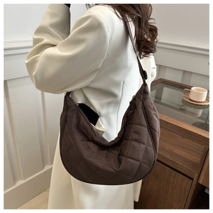 Close-up of brown quilted nylon shoulder bag showing puffy texture and stitching