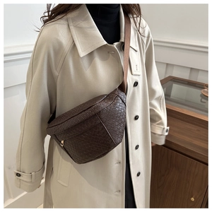 Détail de sac de poitrine tressé marron avec motif crocodile et bandoulière en nylon