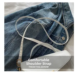 Detailed view of the comfortable white leather shoulder strap with gold metal buckle