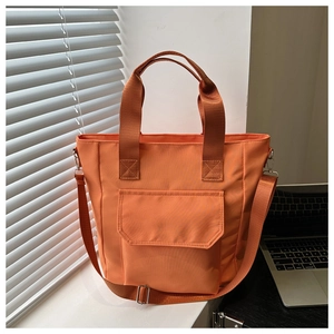 Orange nylon tote bag with reinforced handles and adjustable strap for commuting