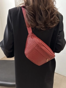 Sac de poitrine tressé bordeaux pour homme avec bandoulière sur une veste noire chic