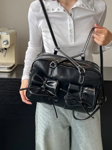 Versatile black faux leather shoulder bag with white stitching and bow pocket detail