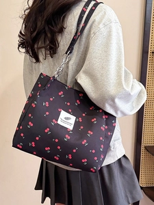 Large black canvas tote bag with red cherry prints and stylish silver metal chain strap
