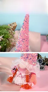 Close-up of pink sequined gnome hat and delicate white lace dress with orange braids