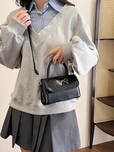 Chic black crossbody bag with silver metal bow and textured leather for women