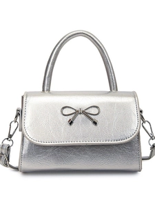 Silver metallic crossbody bag with textured bow accent and detachable shoulder strap