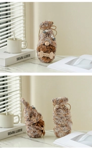 Detailansicht eines gestrickten Hundezwergs mit 'WOOF'-Knochenanhänger und Bart