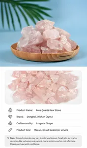 Macro shot of natural raw rose quartz stones in a wooden tray with irregular pink textures