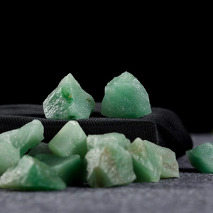 Natural raw green fluorite crystal stones displayed on a premium black tiered stand