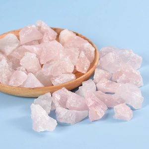 Natural raw rose quartz crystals for fish tanks and aromatherapy on a wooden tray