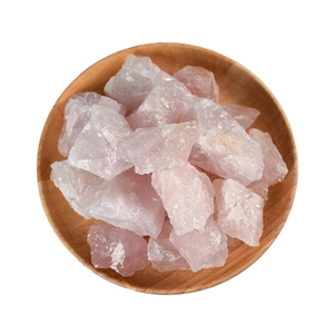 Natural raw rose quartz stones in a wooden tray for home decor and aromatherapy