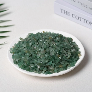 Polished green Aventurine crystal chips in a white ceramic tray for home decoration