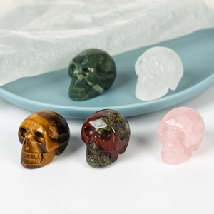 Hand-carved 1.5 inch skull ornaments in rose quartz, tiger eye, and aventurine stones