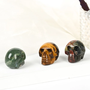 Hand-carved gemstone skulls made of moss agate, tiger eye, and jasper for home decor