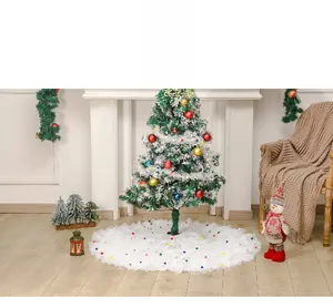 White tulle Christmas tree skirt with colorful pom poms in a cozy festive holiday setting