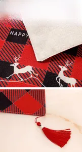 Détail d'un chemin de table de Noël avec motif à carreaux, renne et glands rouges