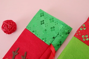 Detail of Christmas wine bottle bags with felt fabric and sequined embroidery reindeer