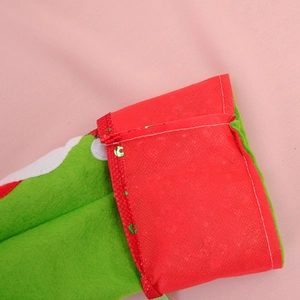 Close-up of sequined green velvet fabric and red non-woven trim for Christmas wine bags
