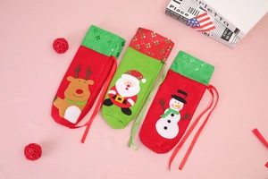 Detail of Christmas wine bottle bags with sequin embroidery and festive character appliques