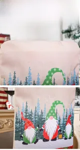 Close-up of linen Christmas chair cover with Merry Christmas text and gnome patterns
