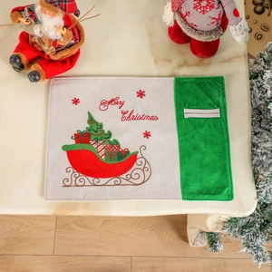 Christmas place mat with Merry Christmas embroidery and red sleigh on marble tabletop