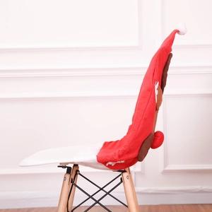 Side view of red Santa hat chair cover with brown reindeer antlers and pompom on white chair