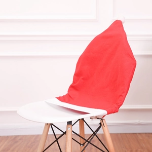 Detailed view of red and white Santa hat chair cover with plush pom-pom on white chair