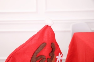 Close-up of red felt Christmas chair cover with brown reindeer antlers and white pom-pom