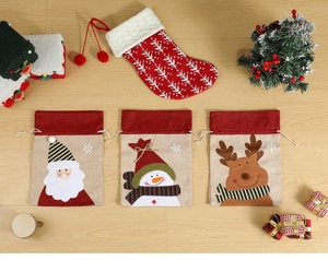 Détail de sacs cadeaux en toile de Noël avec motifs appliqués de Père Noël, bonhomme et renne