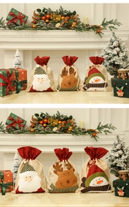 Gros plan de sacs de Noël en toile de jute avec broderies 3D du Père Noël et renne